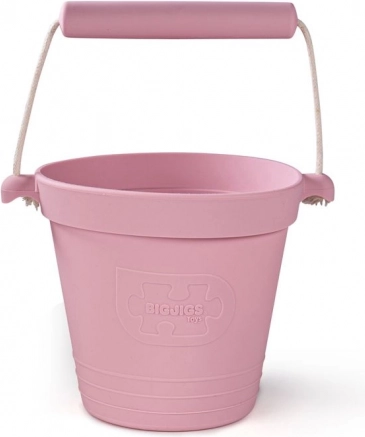 Cubo de playa de silicona rosa claro BIGJIGS TOYS