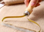 Quitapelusas manual para ropa y tapicería con mango de madera
